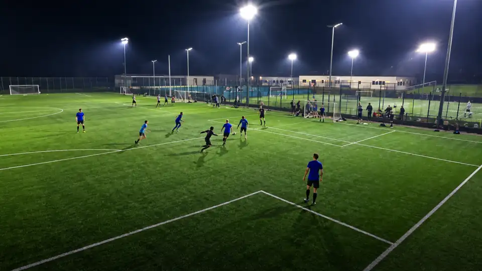SIXFL football pitch under floodlights at night